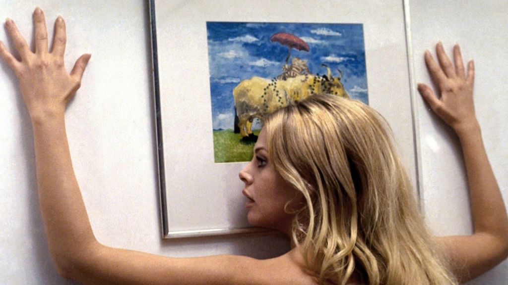 A nude Willow, pressed up against the wall, hands spread and face against a cheerful picture