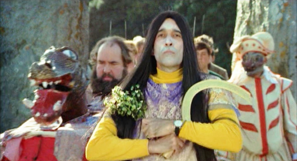 The mummer's parade, led by a crossdressing Lord Summerisle, holding a sickle and a holly branch